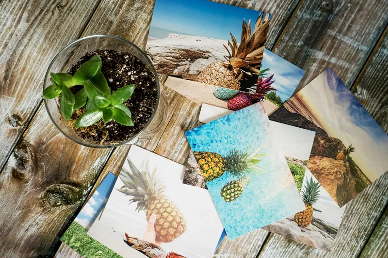 Imagem ilustrativa: fotos impressas espalhadas sobre uma mesa de madeira
